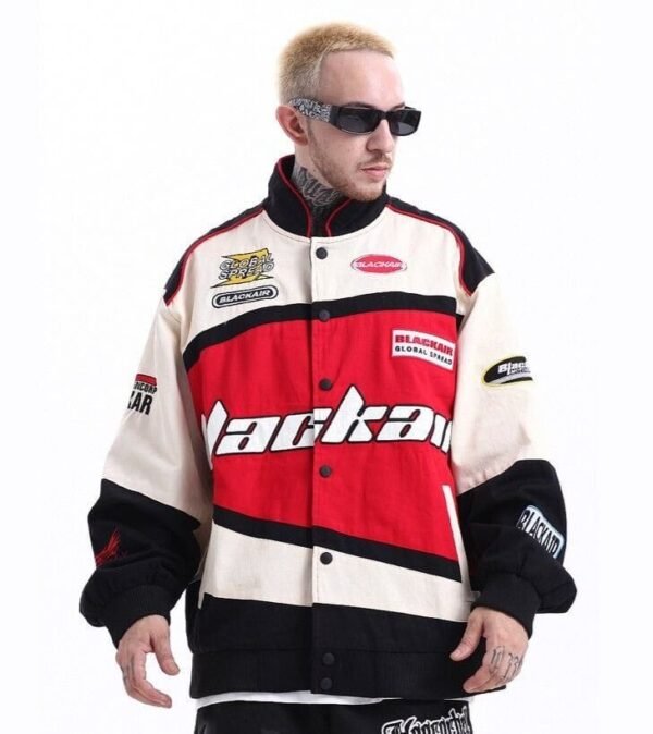 A stylish man wearing a Black Air Racing Jacket, inspired by vintage F1 jackets, standing confidently in an urban streetwear setting