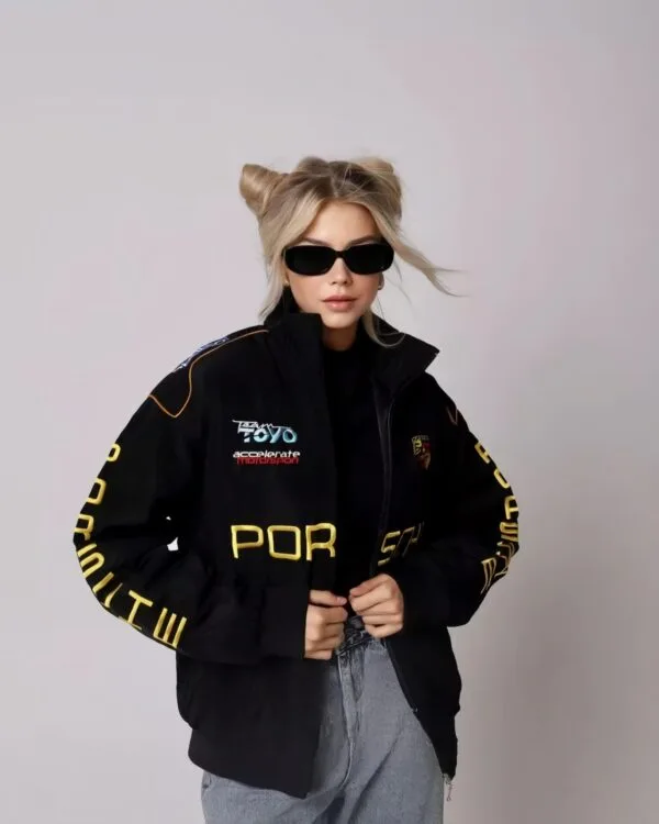 Detailed shot of Porsche bomber jacket sleeves, showcasing patches and intricate embroidery.
