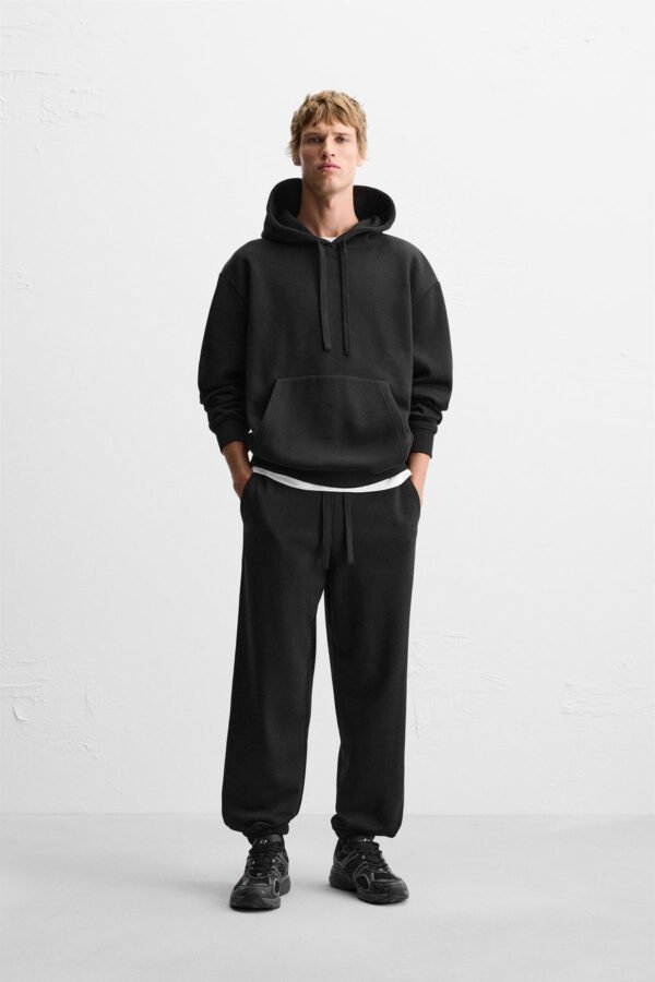Zerodas Classic Black Track Pant styled for urban streetwear, shown on model with casual black sneakers
