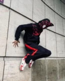 Model wearing black Spiderman zip-up hoodie in urban setting